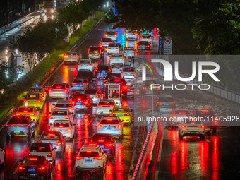 Vehicles are driving slowly in the rainstorm in central Chongqing, China, on July 13, 2024. (