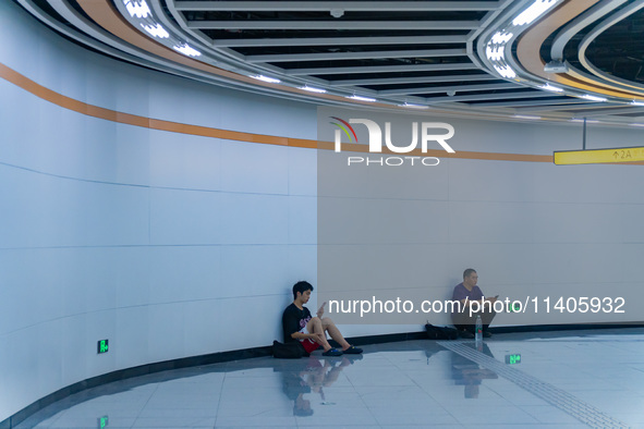 Citizens are cooling off at the platform of Line 4 of the rail transit train in Chongqing, China, on July 13, 2024. 