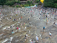 Tourists are enjoying cooling off in the water in Pingnan county, in Fujian, China, on July 13, 2024. (