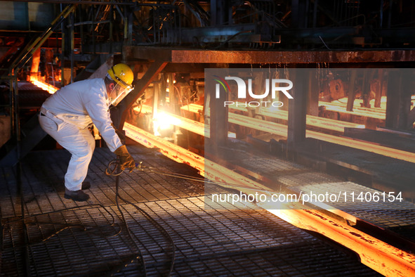 A worker is working at a steel casting workshop of a steel company in Lianyungang, China, on July 13, 2024. 