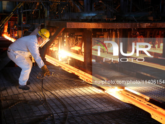 A worker is working at a steel casting workshop of a steel company in Lianyungang, China, on July 13, 2024. (