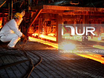 A worker is working at a steel casting workshop of a steel company in Lianyungang, China, on July 13, 2024. (