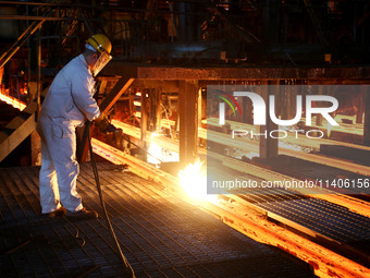 A worker is working at a steel casting workshop of a steel company in Lianyungang, China, on July 13, 2024. (