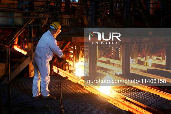 A worker is working at a steel casting workshop of a steel company in Lianyungang, China, on July 13, 2024. 