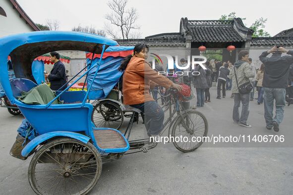 A cyclo driver is waiting for a guest near the national garden in Yangzhou, China. 