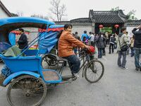 A cyclo driver is waiting for a guest near the national garden in Yangzhou, China. (