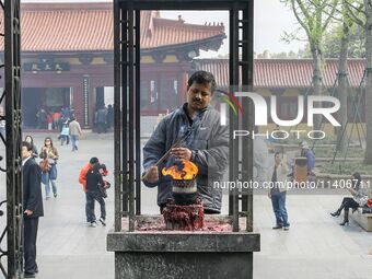 Visitors are praying with incense burning for their happiness at Lingshan Temple in Wuxi, China. (