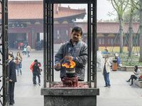 Visitors are praying with incense burning for their happiness at Lingshan Temple in Wuxi, China. (