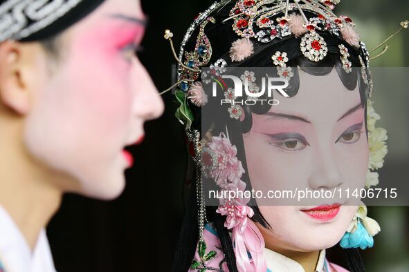 An actor and actress are performing in a Beijing opera at a traditional theatre in Suzhou, China. 