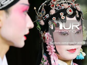 An actor and actress are performing in a Beijing opera at a traditional theatre in Suzhou, China. (