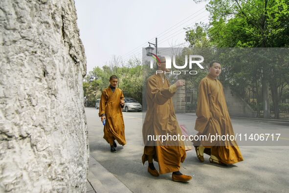 Monks are walking past the street near the North Temple Pagoda in Suzhou, China. 