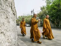 Monks are walking past the street near the North Temple Pagoda in Suzhou, China. (