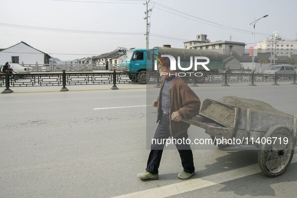 A worker is drawing a handcart in Zhouzhuang town in Suzhou, China. 