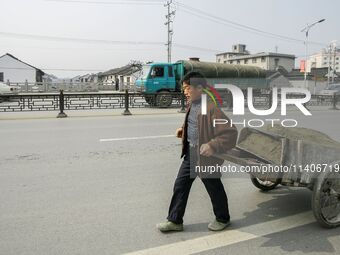 A worker is drawing a handcart in Zhouzhuang town in Suzhou, China. (