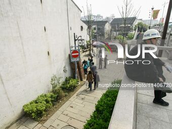 A public security officer is resting on a safety curve in Zhouzhuang town in Suzhou, China. (