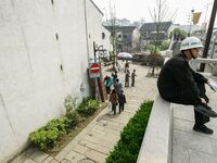 A public security officer is resting on a safety curve in Zhouzhuang town in Suzhou, China. (