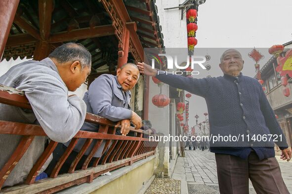 An elderly man is making a funny gesture in Zhouzhuang town in Suzhou, China. 