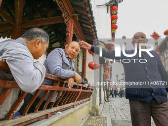 An elderly man is making a funny gesture in Zhouzhuang town in Suzhou, China. (