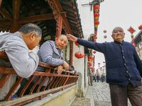 An elderly man is making a funny gesture in Zhouzhuang town in Suzhou, China. (