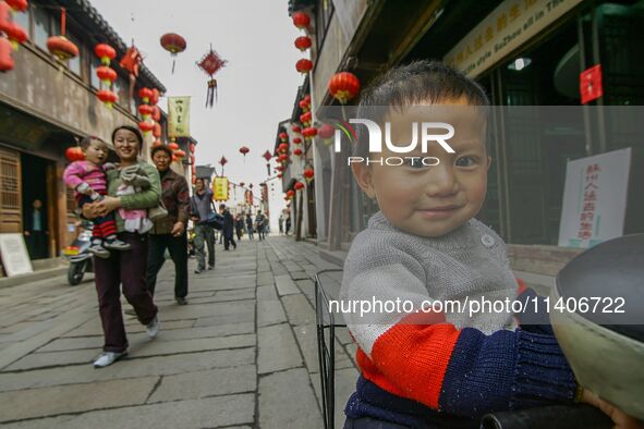 Children are smiling and looking at the photographer in Zhouzhuang town in Suzhou, China. 