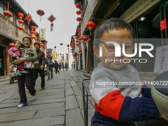 Children are smiling and looking at the photographer in Zhouzhuang town in Suzhou, China. (