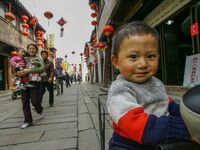 Children are smiling and looking at the photographer in Zhouzhuang town in Suzhou, China. (