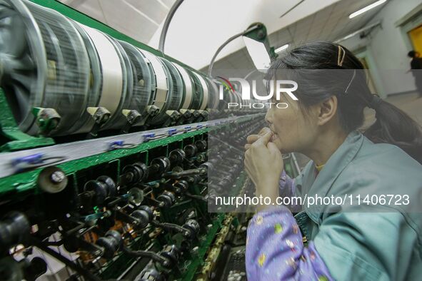 A worker is making silk at a factory in an industrial park in Suzhou, China. 