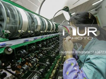 A worker is making silk at a factory in an industrial park in Suzhou, China. (