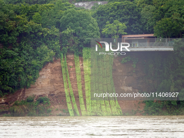 A landslide is occurring near the viewing platform of Mojishan Park on the banks of the Yangtze River in Yichang, Hubei province, China, on...