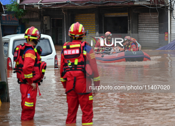 Emergency workers are evacuating stranded people in Neijiang, China, on July 14, 2024. 