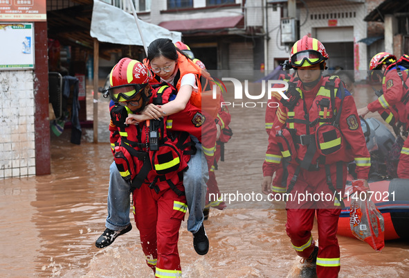 Emergency workers are evacuating stranded people in Neijiang, China, on July 14, 2024. 