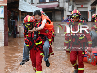 Emergency workers are evacuating stranded people in Neijiang, China, on July 14, 2024. (