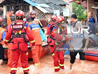 Emergency workers are evacuating stranded people in Neijiang, China, on July 14, 2024. (