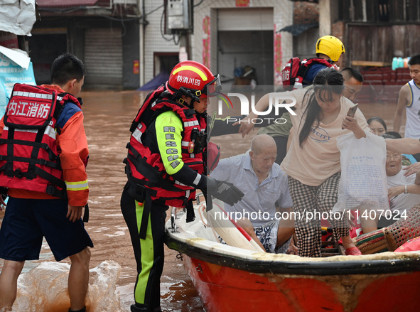 Emergency workers are evacuating stranded people in Neijiang, China, on July 14, 2024. 