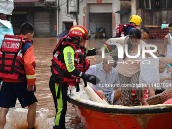 Emergency workers are evacuating stranded people in Neijiang, China, on July 14, 2024. (