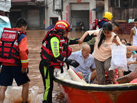 Emergency workers are evacuating stranded people in Neijiang, China, on July 14, 2024. (