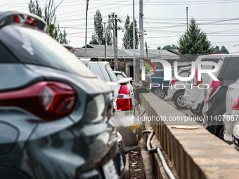 A man is speaking on his phone as he is sitting inside a car parking area in Srinagar, Jammu and Kashmir, India, on July 14, 2024. (