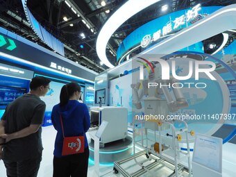 Visitors are visiting a ''special operation robot'' at the 26th China Beijing International Science and Technology Industry Expo in Beijing,...