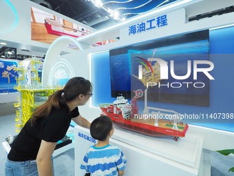 Visitors are viewing a model of ''Offshore Oil 286'' at the 26th China Beijing International Science and Technology Industry Expo in Beijing...