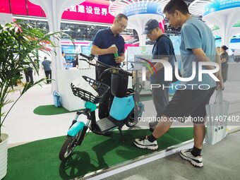 Visitors are visiting a ''hydrogen-powered moped'' at the 26th China Beijing International Science and Technology Industry Expo in Beijing,...