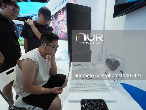 Visitors are playing with a Go robot at the 26th China Beijing International Science and Technology Industry Expo in Beijing, China, on July...