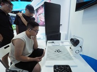 Visitors are playing with a Go robot at the 26th China Beijing International Science and Technology Industry Expo in Beijing, China, on July...