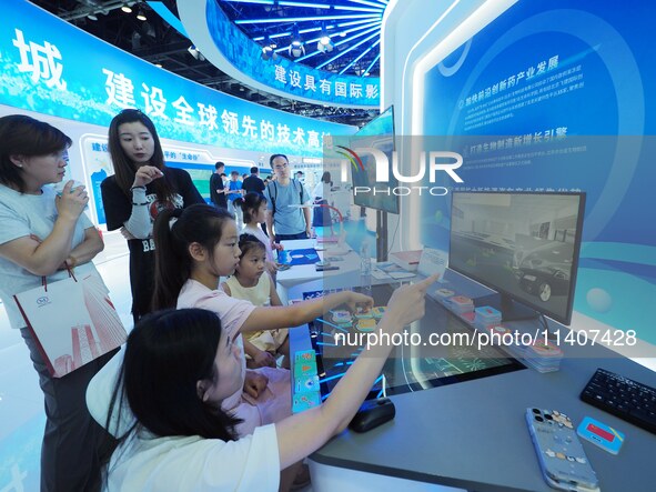 Visitors are experiencing an ''AI intelligent desk'' at the 26th China Beijing International Science and Technology Expo in Beijing, China,...