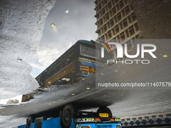 A bus is being reflected in a puddle of rainwater during the monsoon in Kolkata, India, on July 14, 2024. (