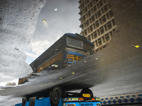 A bus is being reflected in a puddle of rainwater during the monsoon in Kolkata, India, on July 14, 2024. (