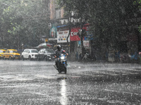 A person is riding a motorcycle during the heavy rain in Kolkata, India, on July 14, 2024. (