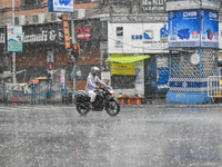 A person is riding a motorcycle during the heavy rain in Kolkata, India, on July 14, 2024. (