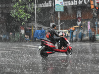 A person is riding an Escooter during the heavy rain in Kolkata, India, on July 14, 2024. (