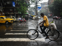 A person is riding his cycle during the heavy rain in Kolkata, India, on July 14, 2024. (