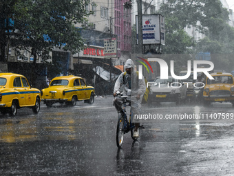 A food delivery person is delivering food during heavy rain in Kolkata, India, on July 14, 2024. (